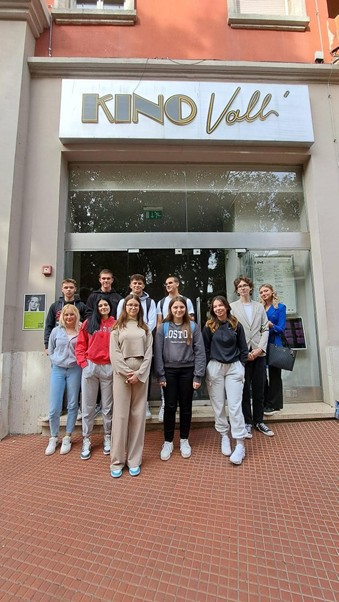 A group of people standing in front of a buildingDescription automatically generated