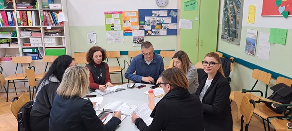 A group of people sitting around a tableAI-generated content may be incorrect.