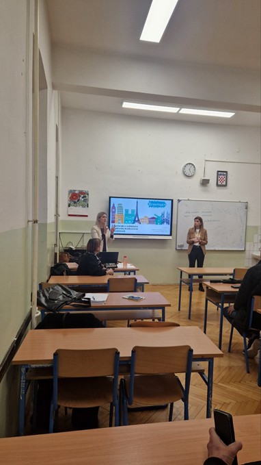 A classroom with a large screen and a person standing in front of a whiteboardAI-generated content may be incorrect.